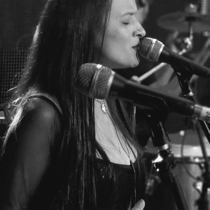 vocalista da banda somnium cantando com microfone